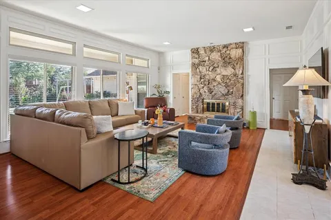 a living room with furniture a flat screen tv and a large window