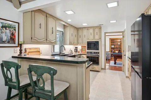 a kitchen with stainless steel appliances granite countertop a stove refrigerator sink and cabinets