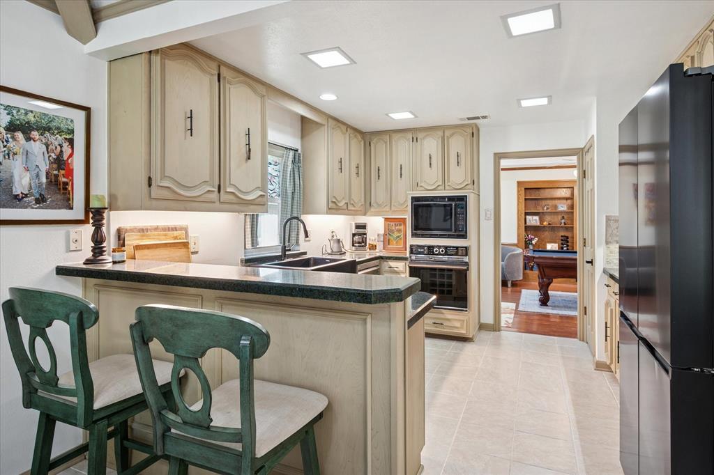 4302 Brooktree Lane Dallas, TX 75287 - Photo 3 of 23 a kitchen with stainless steel appliances granite countertop a stove refrigerator sink and cabinets