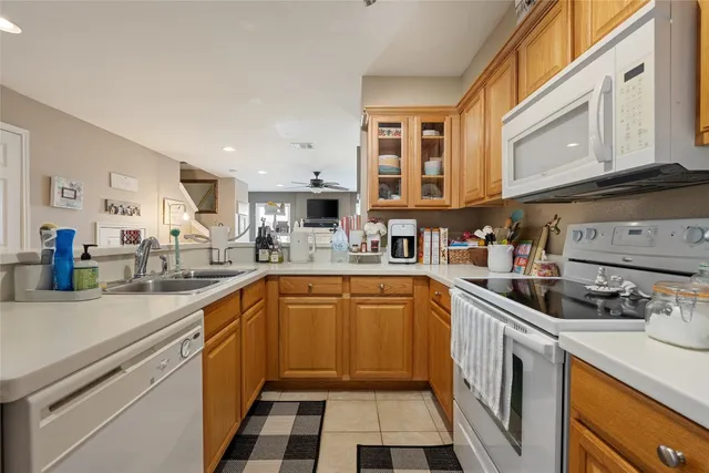 a kitchen with stainless steel appliances granite countertop a sink and dishwasher a stove top oven with white cabinets
