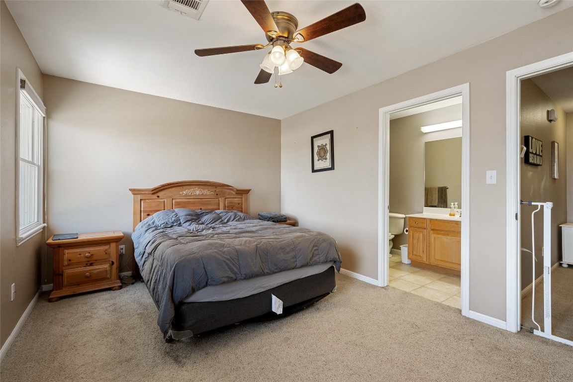 6900 East Riverside Drive, Unit 12 Austin, TX 78741 - Photo 18 of 27 a bedroom with a bed and a chandelier