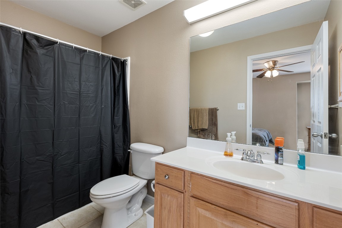 6900 East Riverside Drive, Unit 12 Austin, TX 78741 - Photo 19 of 27 a bathroom with a sink a toilet a mirror and shower curtain