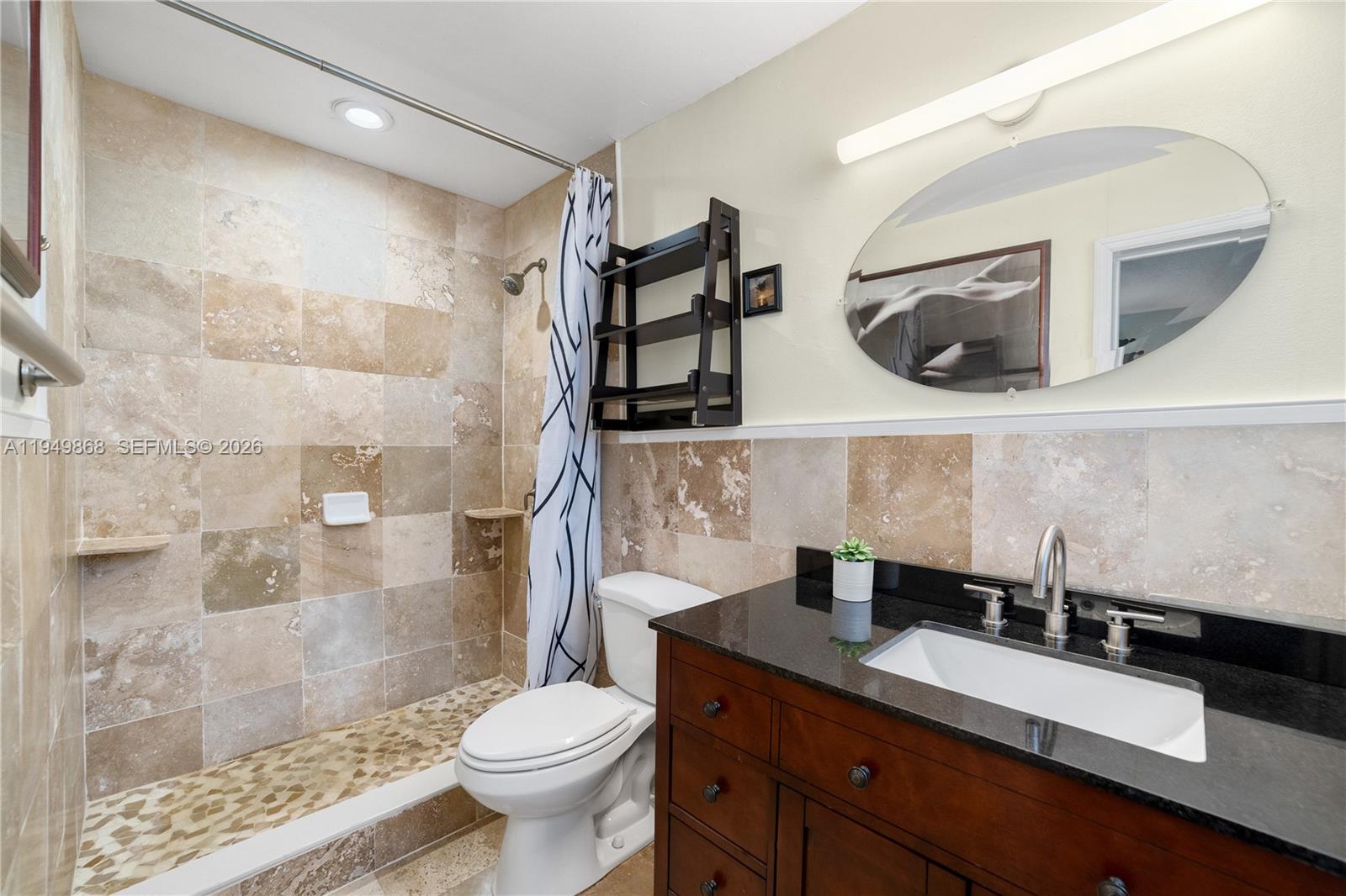 1155 South Biscayne Point Road Miami Beach, FL 33141 - Photo 15 of 23 a bathroom with a granite countertop sink a toilet a mirror and shower