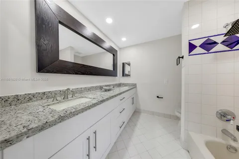 a bathroom with a granite countertop sink a vanity and a shower