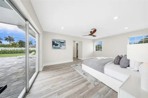 a bedroom with a bed and a large window with balcony view