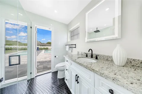 a bathroom with a granite countertop sink a toilet and shower