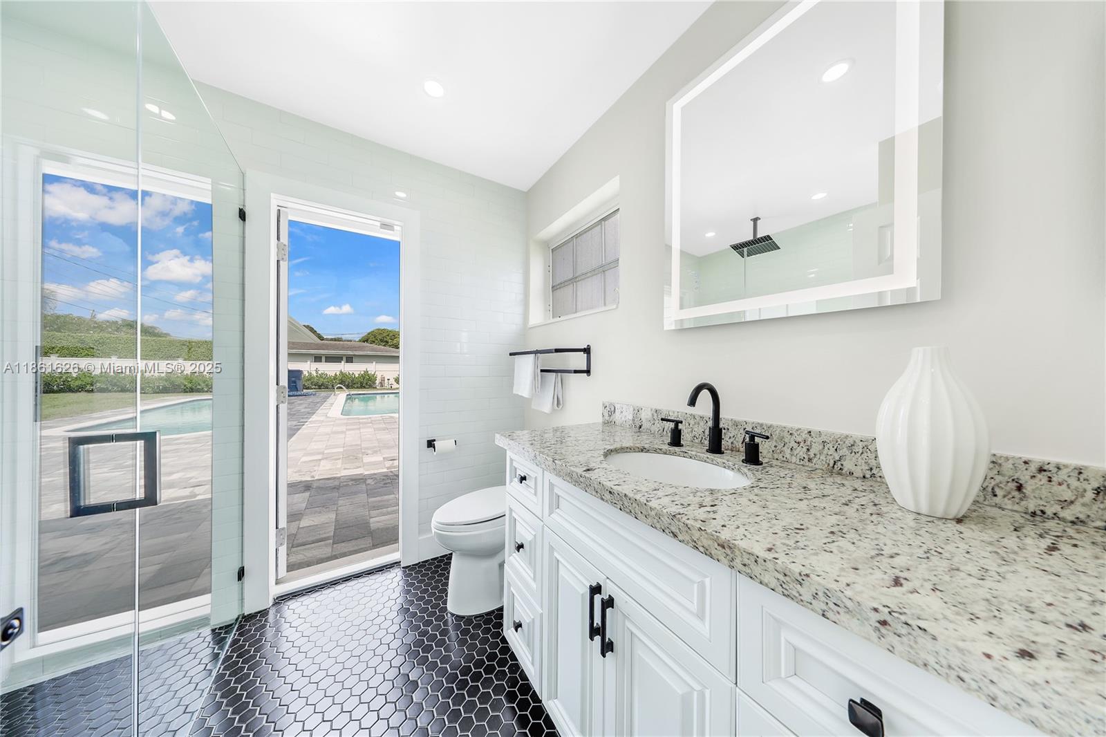 8355 Southwest 89th Street Miami, FL 33156 - Photo 21 of 29 a bathroom with a granite countertop sink a toilet and shower