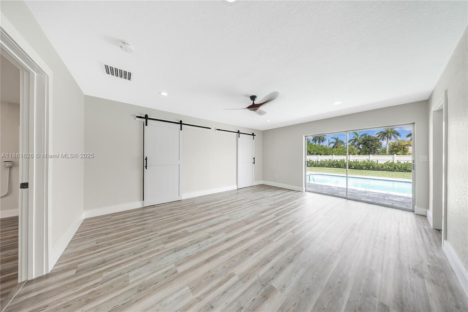 8355 Southwest 89th Street Miami, FL 33156 - Photo 7 of 29 a view of an empty room with wooden floor and a window