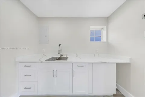 a kitchen with white cabinets and a sink