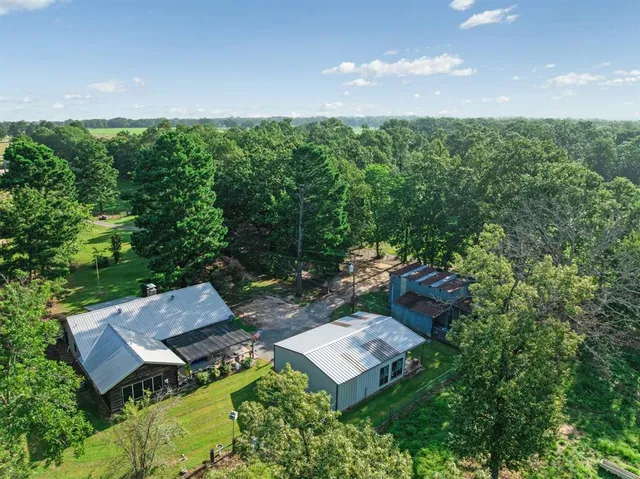 an aerial view of a house with swimming pool and garden