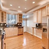 a kitchen with stainless steel appliances granite countertop a refrigerator a stove and a wooden floors