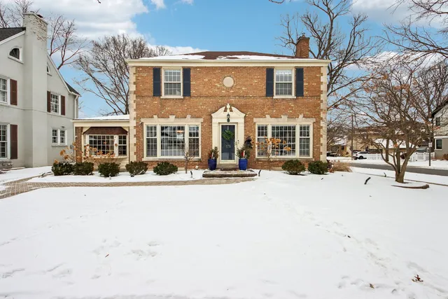 a front view of a building with large trees