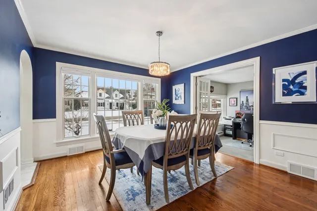 a dining room with furniture a chandelier and wooden floor