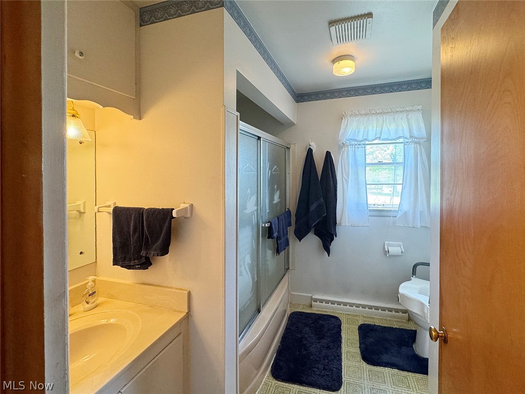5934 Ryan Road Medina, OH 44256 - Photo 12 of 24 Full bathroom featuring a baseboard heating unit, shower / bath combination with glass door, vanity, tile flooring, and toilet