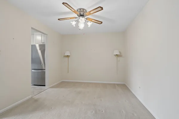 an empty room with ceiling fan and window