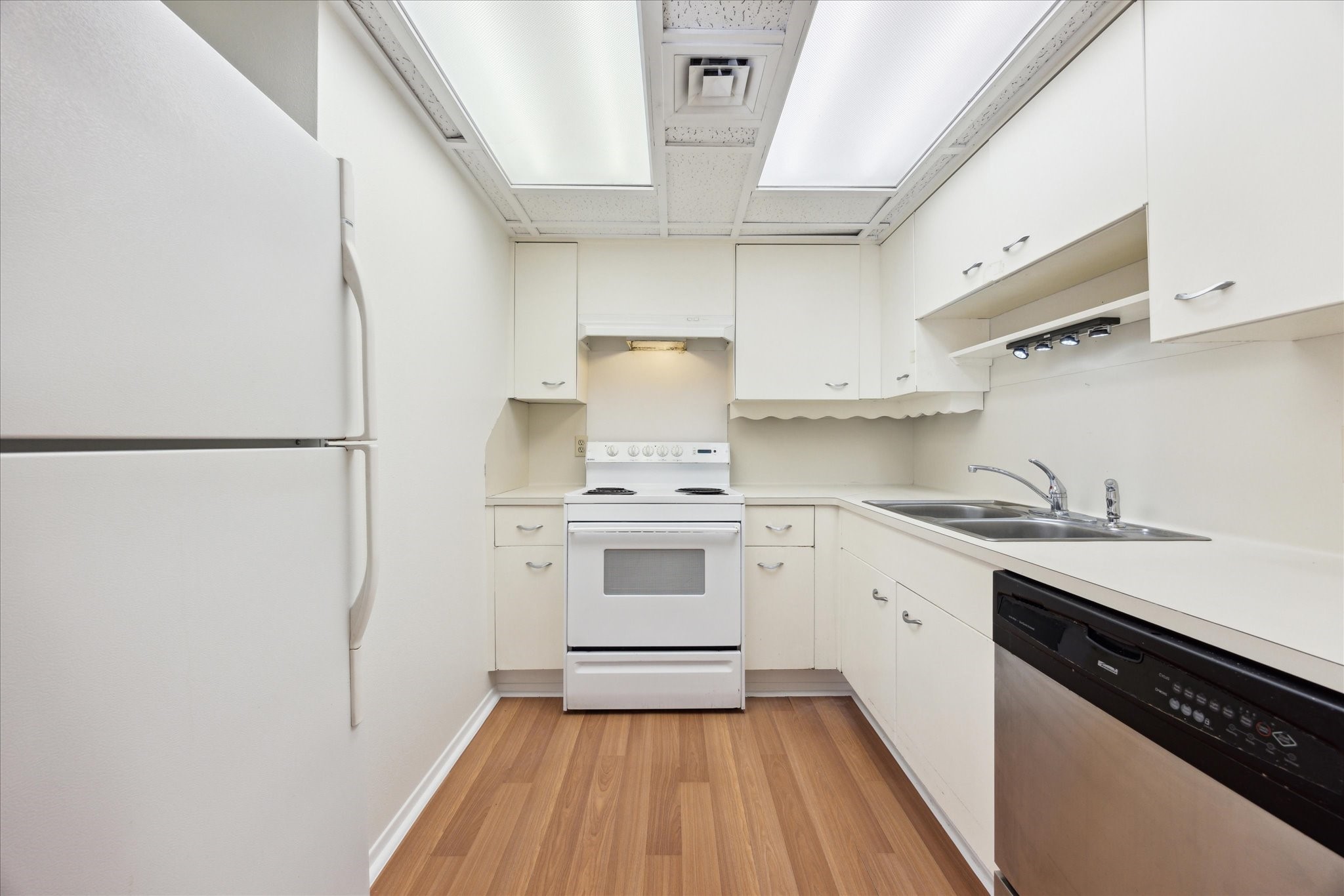 1801 Lavaca Street, Unit 2D Austin, TX 78701 - Photo 9 of 25 a kitchen with a white cabinets and white appliances