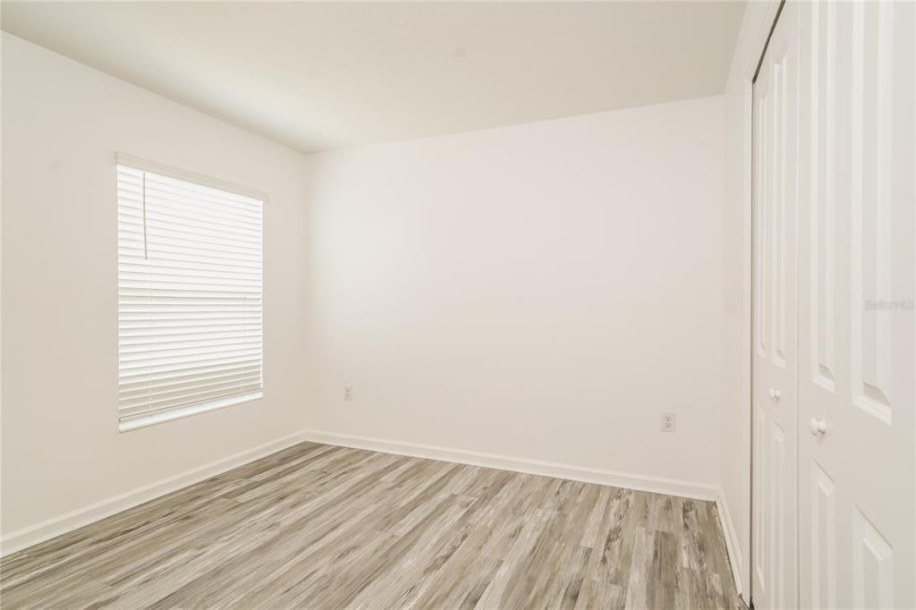 1473 Lucerne Loop Road Northeast Winter Haven, FL 33881 - Photo 17 of 25 a view of an empty room with wooden floor and a window