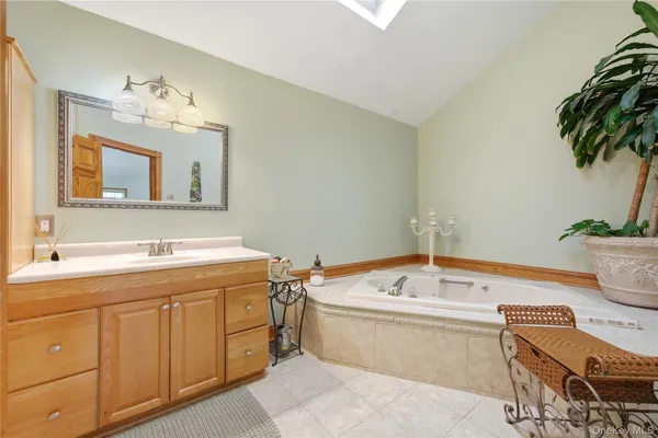 a bathroom with a bathtub a sink and a mirror