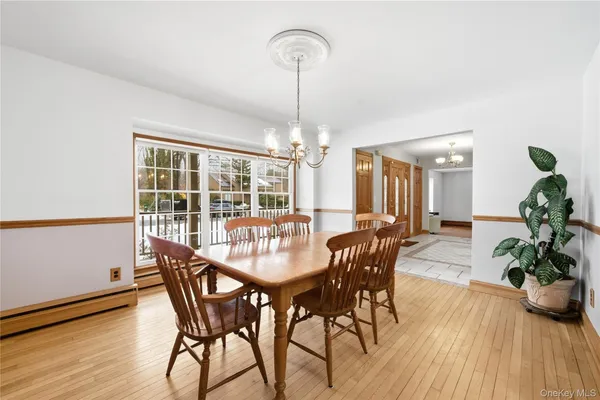 a dining room with furniture potted plants and wooden floor