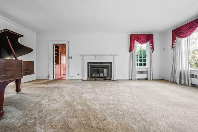 an empty room with windows and fireplace