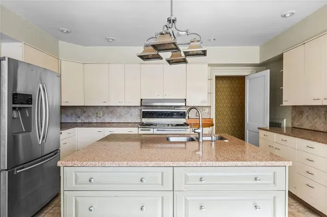 a kitchen with a refrigerator a sink and cabinets