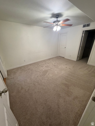 909 South Main Street, Unit F Layton, UT 84041 - Photo 13 of 20 Carpeted interior space featuring a ceiling fan with integrated lighting, white baseboards, and a white paneled door