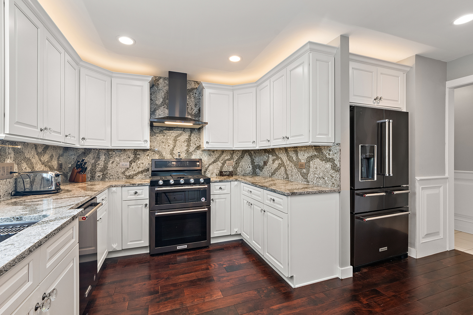305 North Reed Street Joliet, IL 60435 - Photo 16 of 62 a kitchen with granite countertop white cabinets and stainless steel appliances