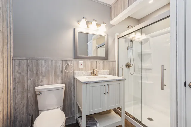 a bathroom with a toilet a sink and mirror