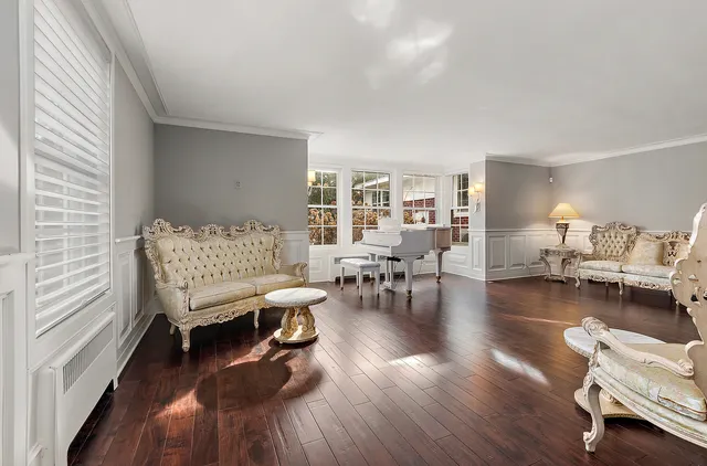 a living room with couches and a fireplace with wooden floor