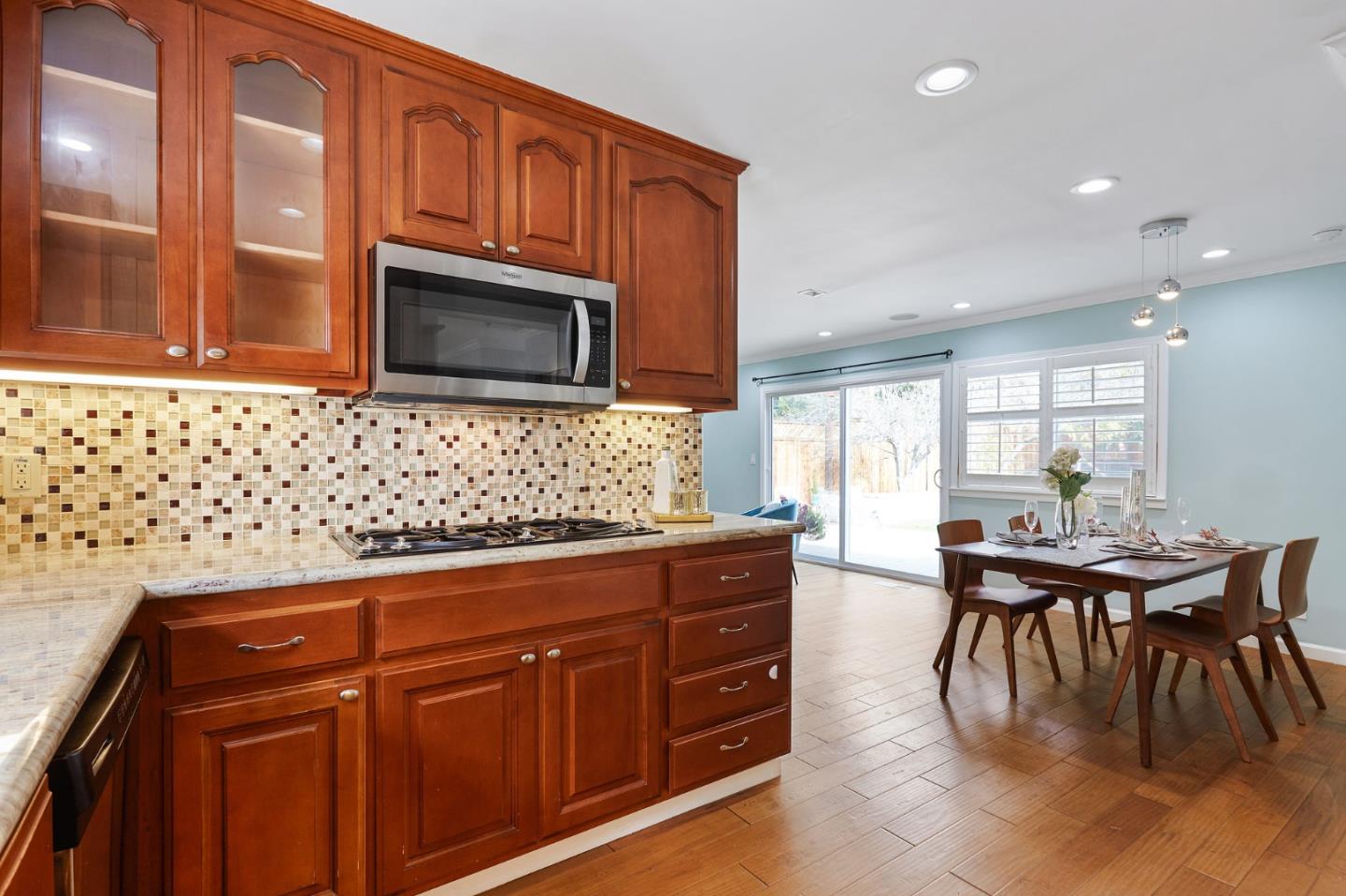 492 Dolores Drive Milpitas, CA 95035 - Photo 17 of 50 a kitchen with granite countertop wooden cabinets dining table and chairs