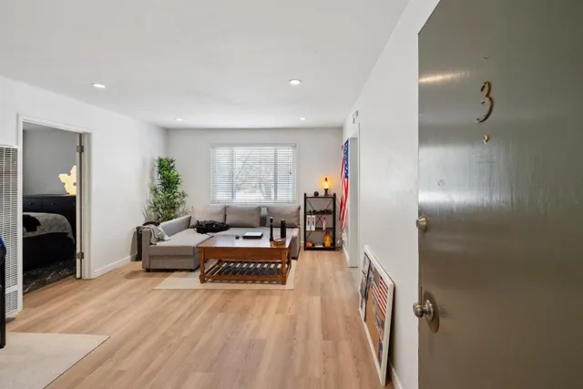 a living room with furniture and a wooden floor