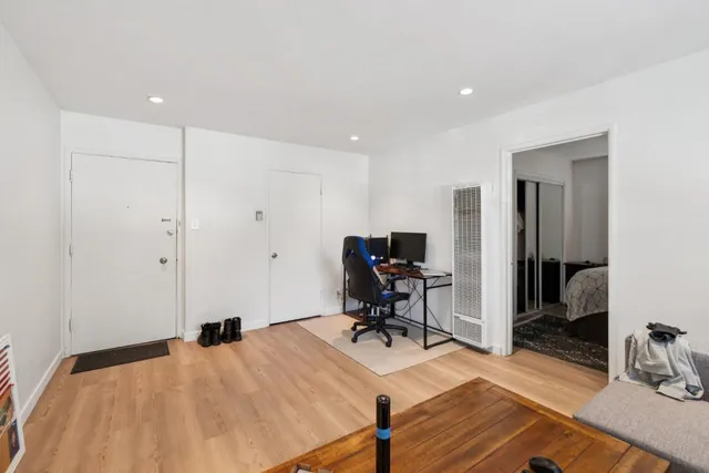 a bedroom with a bed and wooden floor