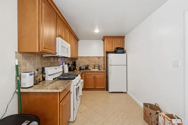 a kitchen with stainless steel appliances granite countertop a sink refrigerator and cabinets