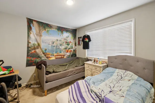 a bedroom with a bed and large window with balcony view