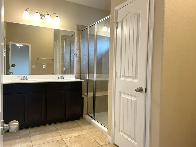 a bathroom with a double vanity sink and a mirror