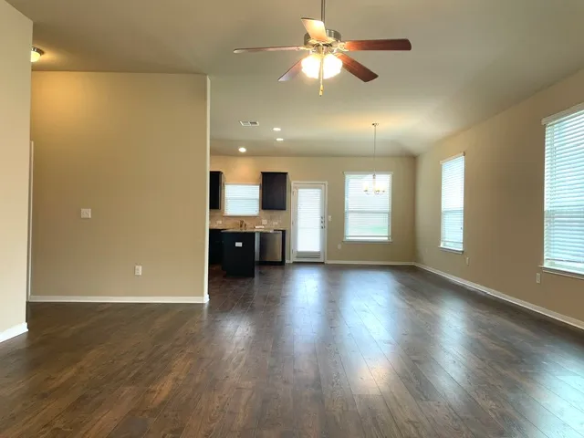 a view of a livingroom with a kitchen wooden floor and a kitchen