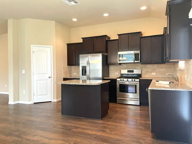 a kitchen with stainless steel appliances wooden cabinets and a counter top space