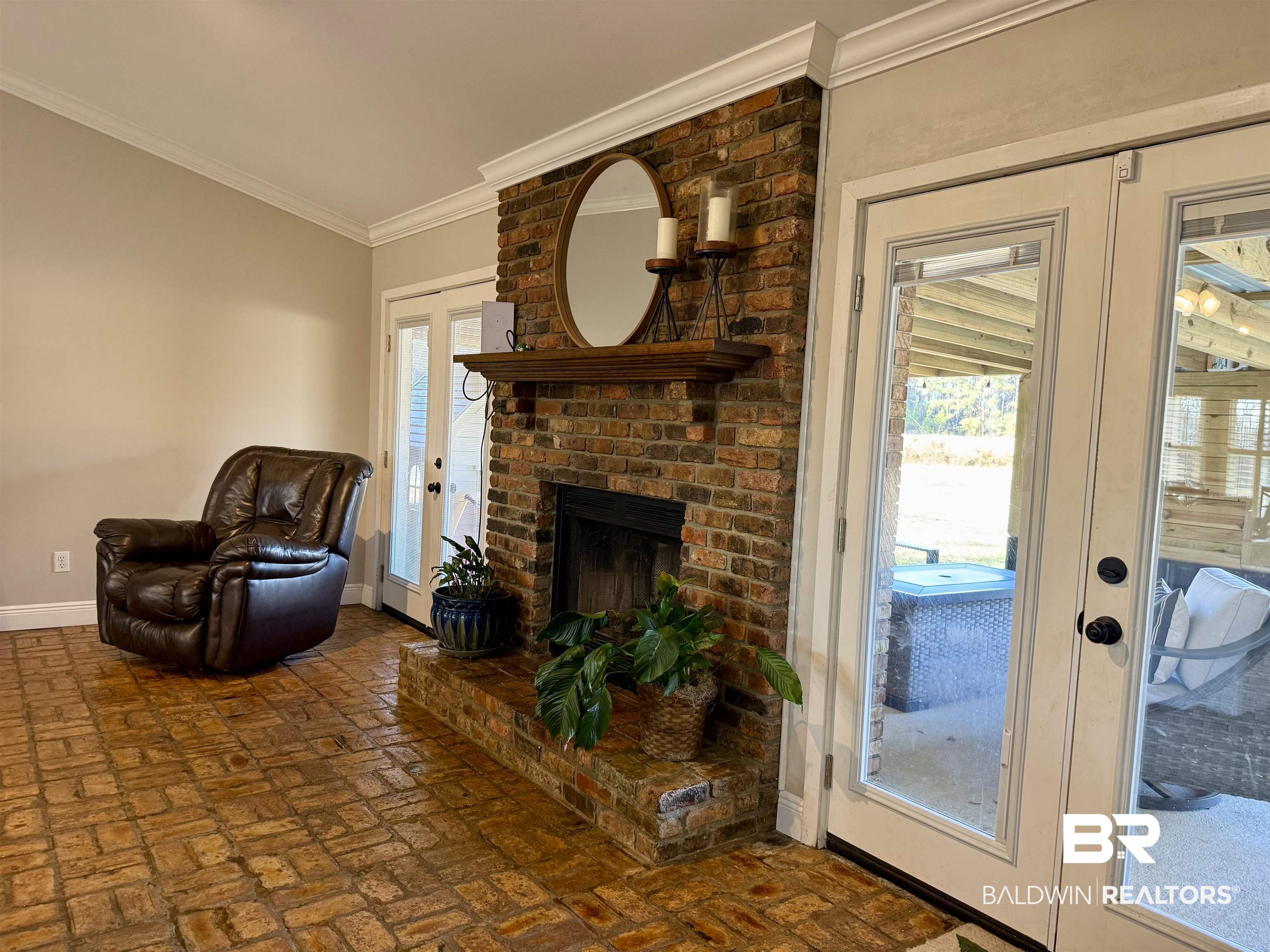5646 Foshee Road Brewton, AL 36426 - Photo 5 of 37 Living room with french doors, a fireplace, brick flooring, and ornamental molding