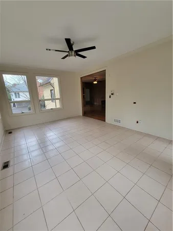 an empty room with windows and ceiling fan