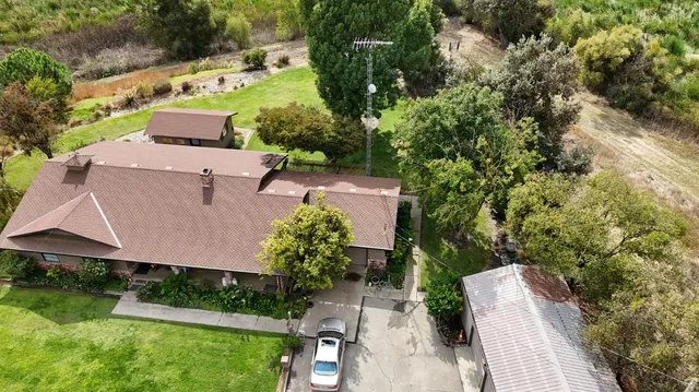 an aerial view of a house with a yard and lake