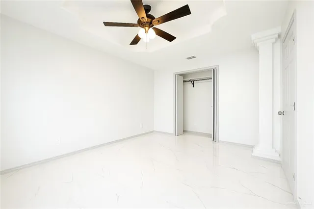 an empty room with a ceiling fan and a window