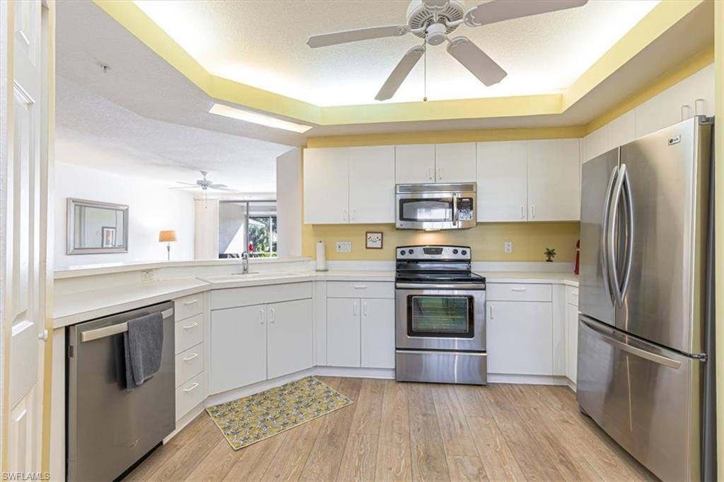 6804 Satinleaf Road South, Unit 102 Naples, FL 34109 - Photo 10 of 35 a kitchen with a sink stove and refrigerator