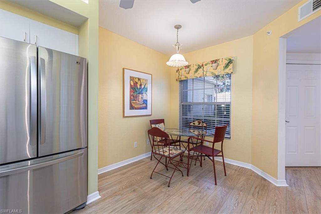 6804 Satinleaf Road South, Unit 102 Naples, FL 34109 - Photo 12 of 35 a view of a dining room with furniture wooden floor and chandelier