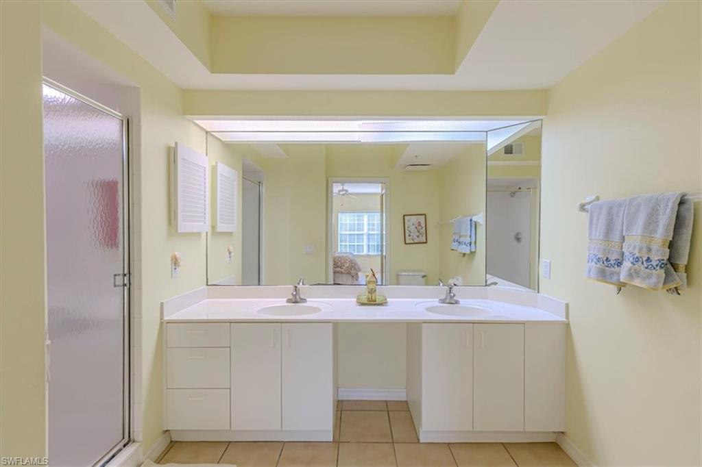 6804 Satinleaf Road South, Unit 102 Naples, FL 34109 - Photo 16 of 35 a bathroom with a sink vanity and mirror
