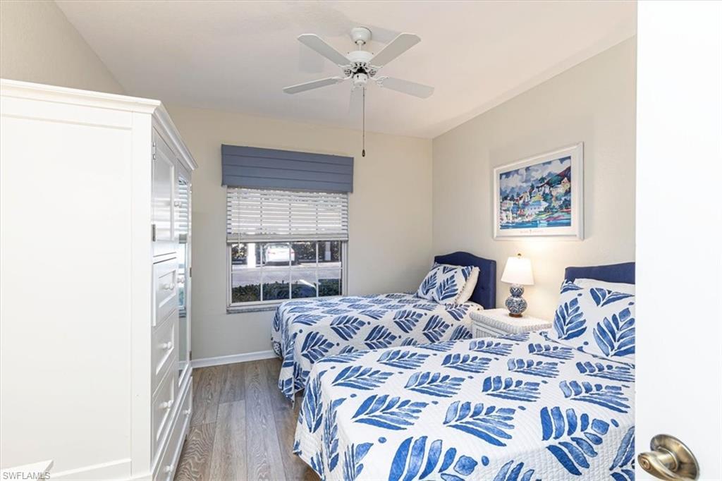 6804 Satinleaf Road South, Unit 102 Naples, FL 34109 - Photo 18 of 35 a bedroom with a bed and a chandelier