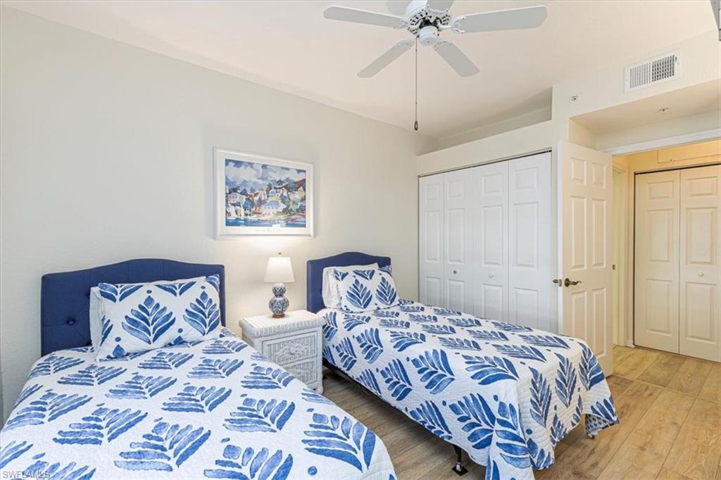 6804 Satinleaf Road South, Unit 102 Naples, FL 34109 - Photo 19 of 35 a bedroom with double bed and a chandelier