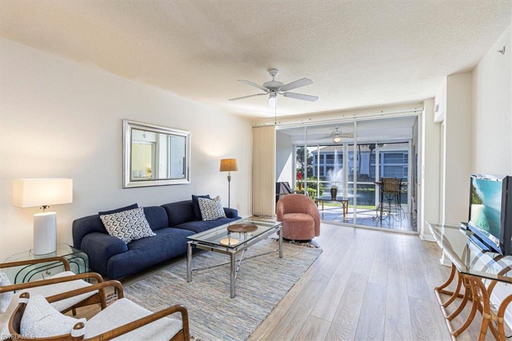 6804 Satinleaf Road South, Unit 102 Naples, FL 34109 - Photo 2 of 35 a living room with furniture and a wooden floor