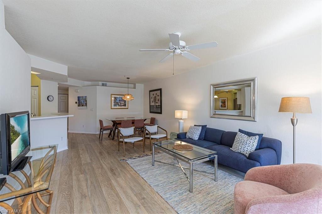 6804 Satinleaf Road South, Unit 102 Naples, FL 34109 - Photo 6 of 35 a living room with furniture and a wooden floor