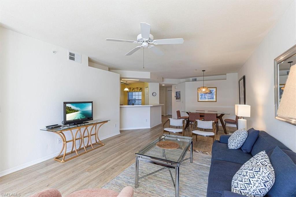 6804 Satinleaf Road South, Unit 102 Naples, FL 34109 - Photo 7 of 35 a living room with furniture a flat screen tv and a window