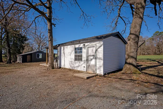 a view of a house with backyard and trees